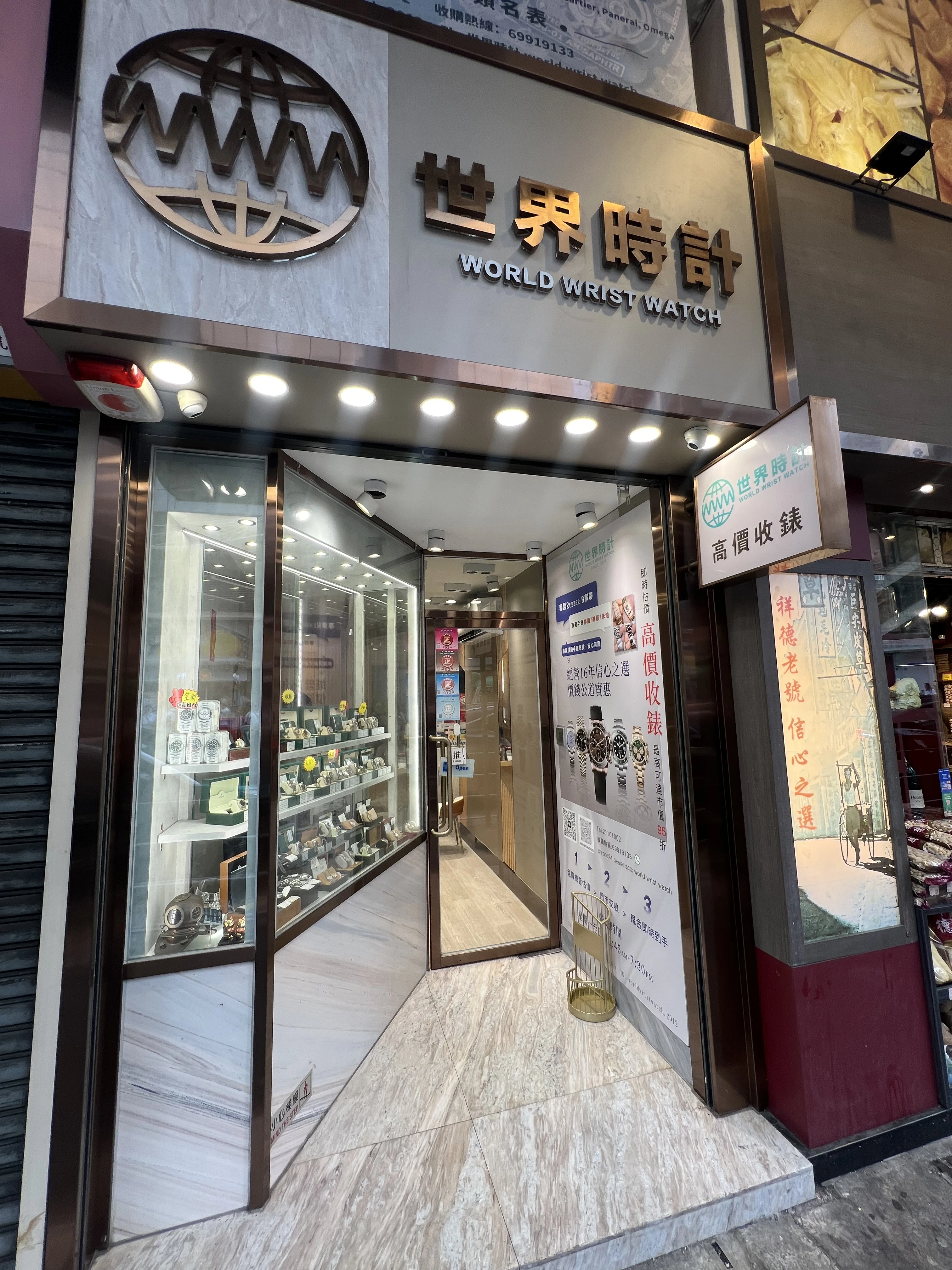 The exterior of the storefront of "World Wrist Watch," a pre-owned luxury watch shop in Yuen Long, which offers buying, selling, purchasing, and consignment services for luxury watches.